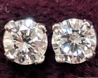 Close-up front view of the pair of round brilliant cut lab diamond earrings set in 14K gold prong settings.