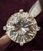 Top-down close-up showing round brilliant diamond and four-prong setting