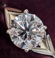 Close-up top view of round brilliant-cut diamond and six-prong setting