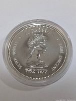 Obverse side of the Canadian Silver Jubilee dollar coin showing Queen Elizabeth II portrait and commemorative text.