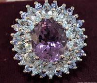 Close-up view of the ring top showing amethyst center surrounded by blue topaz and tanzanite stones.