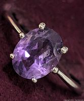 Close-up image of the sterling silver oval amethyst ring showing the prong setting and faceted stone.