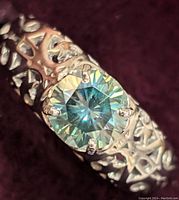 Close-up photo of the sterling silver ring with a round 1.18ct moissanite stone showing intricate band detailing.