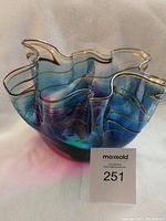 View of the bowl showing the ruffled edges with gold accent lines and blended colors in natural light.