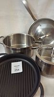 Photo showing the stainless steel stockpot, saucepan with lid, fry pan, and cast aluminum ribbed griddle pan with handle.