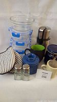 Overview of all kitchen items including coffee grinder, storage containers, salt and pepper shakers, mugs, oven mitts.