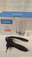 Box of Köök brand stemless champagne flutes model 1050 with the set of 8 flutes inside, along with Screwpull wine bottle opener placed in front.