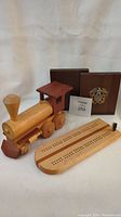 Wooden freight engine, cribbage board, and bookends arranged on white background.