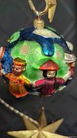 Close-up view of children figures on the globe ornament emphasizing detailed hand-painted faces and cultural costumes.