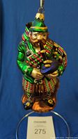 Front view showing the full figure of the Scottish man in traditional attire playing bagpipes.