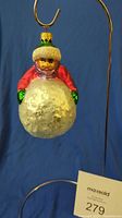 Front view of the Radko glass ornament showing the child holding the snowball with colorful clothing and textured snowball.