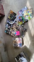 Overhead view of multiple bundles of Game Informer magazines and additional video game magazines/items on a concrete floor