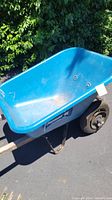 Full view of blue Jackson wheelbarrow showing the plastic tub and metal handles.