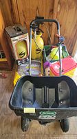 View of Scotts Pro spreader with several garden products including Round Up and Turf Builder beside it in a wooden shed