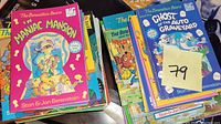 Photo showing a stack of colorful Berenstain Bears children's books including 'In Maniac Mansion,' 'The Ghost of the Auto Graveyard,' and others.