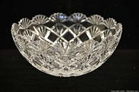 Side view of the clear cut crystal bowl showing scalloped rim and sea shell cut pattern on body.
