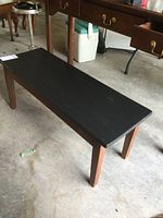 Image showing the full top surface and legs of the solid wood bench with black painted top and natural wood legs.