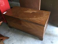 Top side view showing significant finish wear, scratches, and discoloration on the chest lid