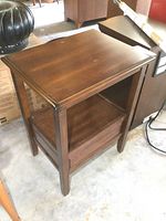 Side and front angle view of solid wood end table showing drawer, lower shelf, and wood grain.