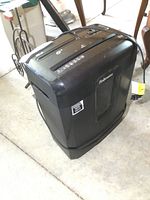 Front and side angle of black Fellowes shredder showing paper and CD slot with power cord and control panel on top