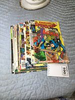 Stack of 11 vintage superhero comics featuring Spider-Man and Batman on covers.
