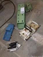 Overview of all vintage Tonka metal toys and the horse trailer with horses on a concrete floor