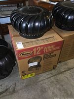 Black 12-inch Master wind turbine roof vent sitting on the original box highlighting the packaging and branding.