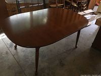 Solid wood Vilas dining table from an angle showing full tabletop with wood grain and rounded corners.