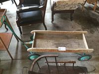 Side and top view of an older wooden kids wagon with a metal frame and teal wheels, showing wear and outdoor exposure. The wooden bed is weathered and the sides have red painted text 'SUPER EXPRESS'. A metal handle for pulling is attached.