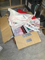 Three fabric tree skirts in a cardboard box