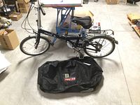 Full side profile of unfolded bicycle with carry bag laid in front