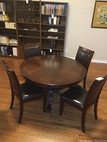 Full view of round table and four chairs in room