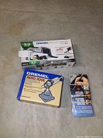 Boxed Dremel Multi-Max MM30 Oscillating Tool, Moto-Tool Holder Base, and flex-shaft accessory leaflet arranged on floor.