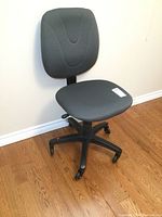 Office chair viewed at an angle showing padded seat, backrest, and five-wheel black base.