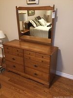 Front view of the solid maple dresser with mirror attached showing drawer configuration and handles.