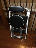 Folding metal step stool and folding seat folded together, showing size and compactness