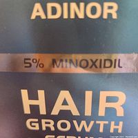 Close-up of the box front showing '5% MINOXIDIL HAIR GROWTH' branding.