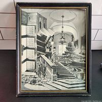 Framed black and white surreal architectural collage photo art showing a staircase, statue, open door and garden maze inside a hallway.