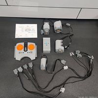 Overview of all items including remote control, motors, battery box, cables, and instructions on a flat black surface