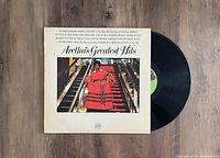 Photo showing the Aretha Franklin Aretha's Greatest Hits vinyl LP record with cover and vinyl partially out.