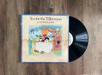 Photo shows the Cat Stevens Tea For The Tillerman album cover with the vinyl partially pulled out on a wooden floor.