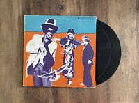 Front of album cover showing colorful artwork with three stylized figures, blue and orange background, and Joni Mitchell name at top right.