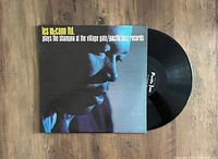 Vinyl record partially out of album cover showing front artwork and label.