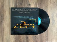 Pat Metheny Group Offramp vinyl LP record and cover sleeve laid flat, showing album cover with turn left road marking and black vinyl disc partially out of sleeve.