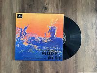 Full view of Pink Floyd 'More' vinyl record partially out of original cover sleeve on wooden floor.
