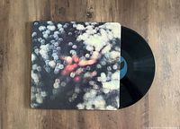 Vinyl record partially visible with gatefold cover closed showing abstract blurred cover art.