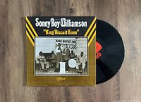 Photograph of the Sonny Boy Williamson 'King Biscuit Time' vinyl LP record with album cover on a wooden surface. The album cover is in front, showing the artwork, and the vinyl record is partially visible beside it.