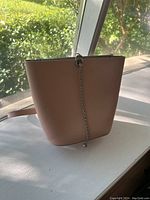 Light brown Zara crossbody bucket-style bag front view with chain detail