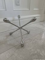 Side view of the silver metal table decoration showing its structure and shiny finish