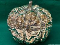 Close-up view of the shiny, metallic pumpkin decor showing details of the texture and reflective surface.